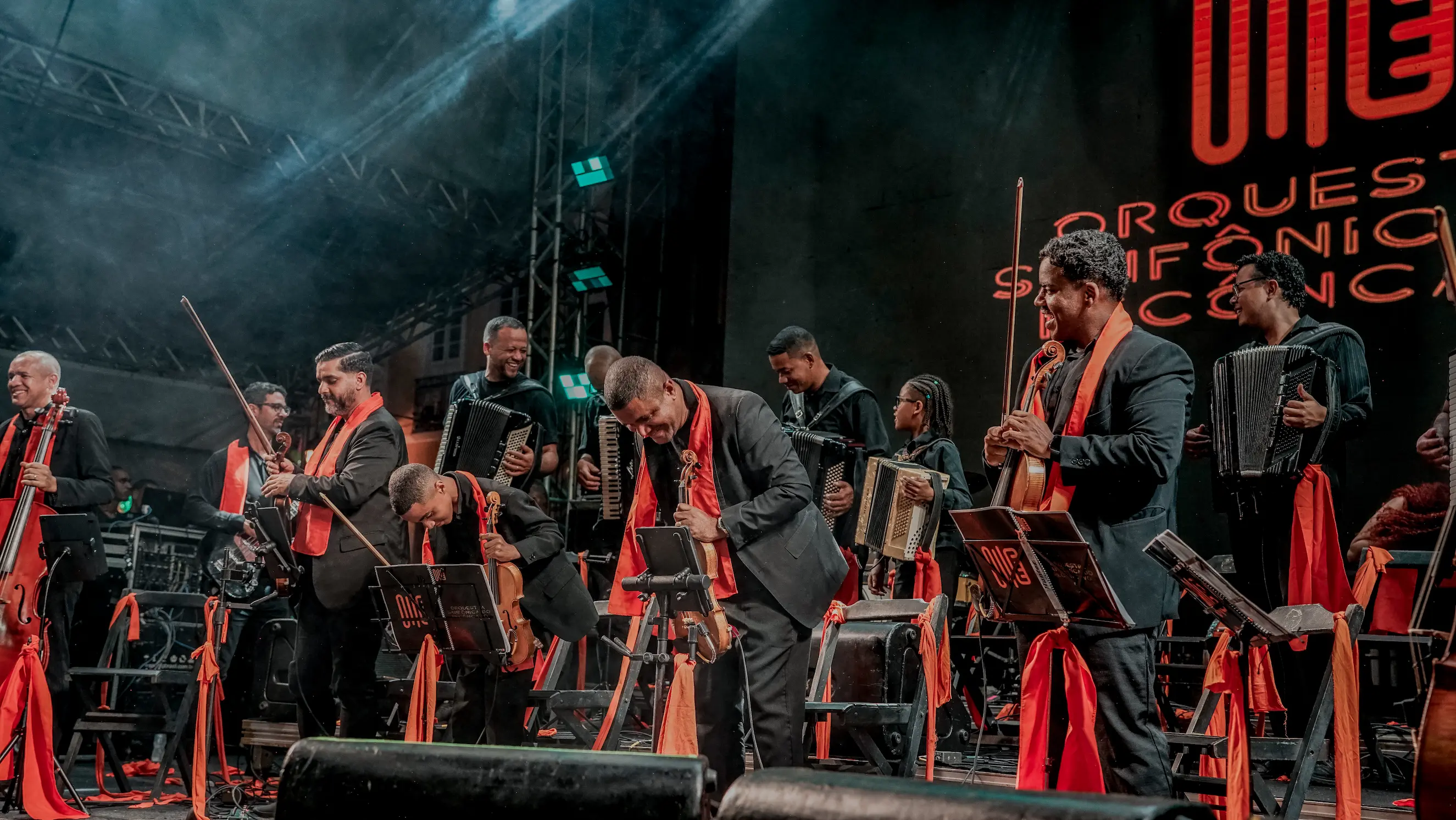 Músicos ensaiando com sanfonas em um salão histórico